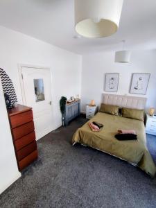 a bedroom with a bed and a dresser at Stadium Solution Flat in London