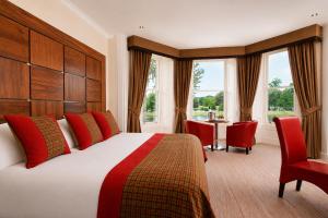 a hotel room with a bed and a table and chairs at The Glenmoriston Townhouse Hotel in Inverness
