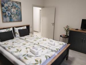 a large bed in a bedroom with a painting on the wall at Апартамент ДОРА in Kazanlŭk