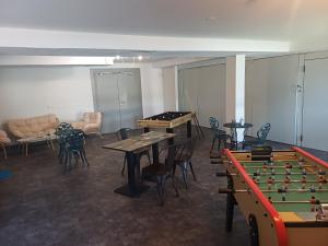 a room with a pool table and ping pong tables at The Originals Access, Hôtel Clermont-Ferrand Nord in Châteaugay