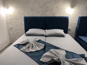 a bed with a blue headboard and two towels on it at Ana L2 in Constanţa