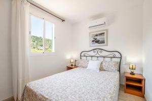 a white bedroom with a bed and a window at Can Freixa - Sóller in Sóller +19 photos