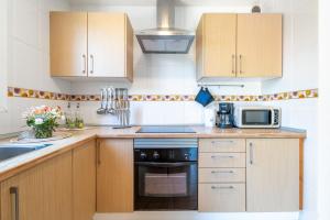 a kitchen with wooden cabinets and a stove top oven at Can Freixa - Sóller in Sóller