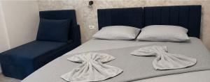 a bed with two towels on it with a chair at Ana L2 in Constanţa +7 photos