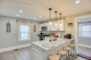 a kitchen with a large island with bar stools at Charming Condo near Gillette Stadium in Sharon
