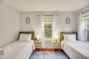 two beds in a room with two windows at Charming Condo near Gillette Stadium in Sharon
