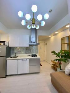 a kitchen with white cabinets and a ceiling at Azure Urban Resort Residences St Tropez Tower Near SM Bicutan with Wave Pool in Manila