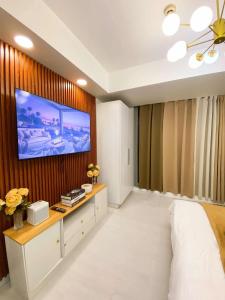 a bedroom with a tv on a wooden wall at Azure Urban Resort Residences St Tropez Tower Near SM Bicutan with Wave Pool in Manila