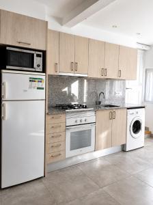a kitchen with a white refrigerator and a dishwasher at Villa Montserrat in Bagá