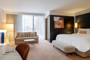 a hotel room with a large bed and a couch at Renaissance Paris Arc de Triomphe Hotel in Paris