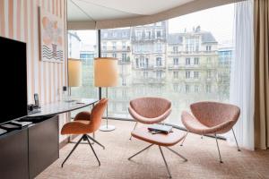 a room with two chairs and a desk and a large window at Renaissance Paris Arc de Triomphe Hotel in Paris +105 photos