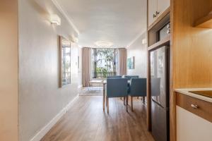 a dining room with a table and blue chairs at Breakers Resort 316 Umhlanga in Durban