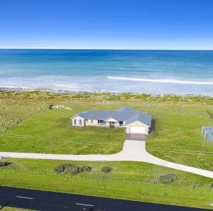a house on the side of a road next to the ocean at Luxurious Home on the Beachside in Port MacDonnell +9 photos