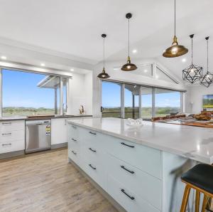 a kitchen with white counters and large windows at Luxurious Home on the Beachside in Port MacDonnell