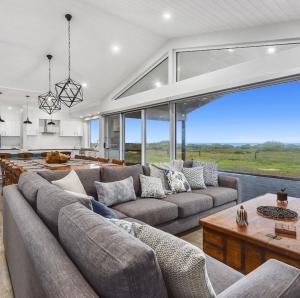 a living room with a couch and a large window at Luxurious Home on the Beachside in Port MacDonnell