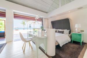 a bedroom with a bed and a table and a desk at Iniala Beach House in Natai Beach