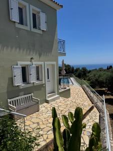 a house with a staircase leading up to a patio at Captains View in Kefallonia
