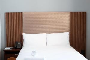 a bedroom with a white bed and a telephone at Galenia Boutique Hotel in Springbok