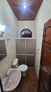 a bathroom with a white toilet and a sink at Casa em Salinas in Salinópolis