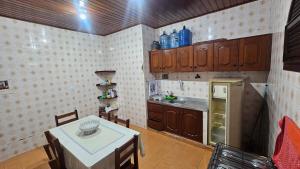 a small kitchen with a table and a refrigerator at Casa em Salinas in Salinópolis +13 photos