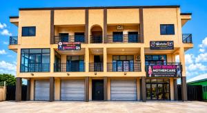 a building with two garage doors and a sign on it at Maatambaba Homes in Tamale