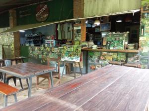 a large wooden table in a restaurant with chairs at Mr Deang shop Doi Inthanon bird center in Ban Na Yang