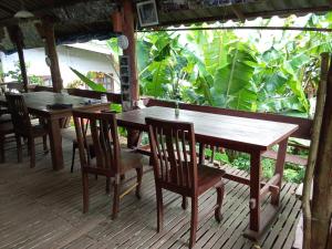two wooden tables and chairs on a porch at Mr Deang shop Doi Inthanon bird center in Ban Na Yang