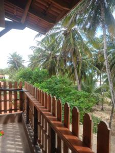 a wooden fence with palm trees in the background at Casa pénareia in Amontada +12 photos