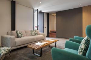 a living room with a couch and a table and chairs at Habitat Boutique Hotel in Catania +55 photos