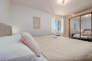 a white bed in a bedroom with a mirror at Villa Ivana holiday home in Mrljane +37 photos