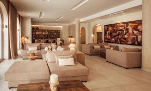 a large living room with couches and a painting at Hotel Well and Come Málaga in Málaga
