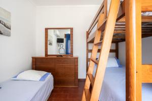 a bedroom with two bunk beds and a mirror at Apartamento Vargas in Monte Gordo