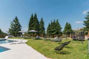 a yard with chairs and a pool and trees at TerraSena Mountain Village - Serra da Estrela in Seia