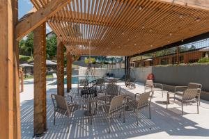 a patio with chairs and a table under a wooden pergola at TerraSena Mountain Village - Serra da Estrela in Seia