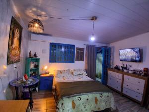 a bedroom with a bed and a table in it at Santa Monica Beach Tiny House in Guarapari
