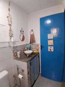 a bathroom with a sink and a blue door at Santa Monica Beach Tiny House in Guarapari