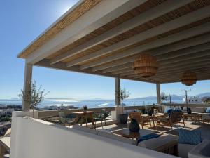 a patio with chairs and tables on a roof at Ostria View Resort in Mikonos +66 photos