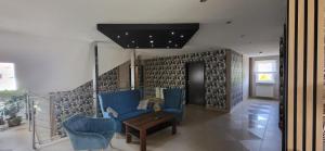 a living room with blue chairs and a table at Villa Rekin in Grzybowo