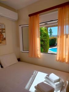 a bedroom with a bed and a window with towels at Serenity Horizon Villa in Theologos +81 photos