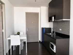 a kitchen with a white table and a white chair at Infinity Pool at Pattaya Posh in North Pattaya