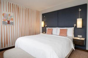 a bedroom with a large white bed with orange pillows at Renaissance Paris Arc de Triomphe Hotel in Paris