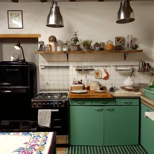 a kitchen with green cabinets and a stove top oven at La Casa di Marla in Sirmione