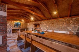 a room with wooden benches and a stone wall at Villa Ivana holiday home in Mrljane