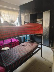 a bedroom with two bunk beds in a room at Kioneki Hostel in Nairobi