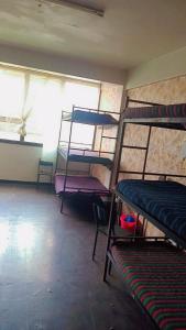 a room with several bunk beds and a window at Kioneki Hostel in Nairobi