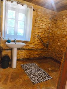 a stone bathroom with a sink and a window at Chambre de la Tour 1 in Milhac