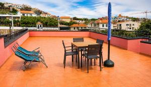 a table and chairs sitting on a roof at Abreu's Place in Câmara de Lobos