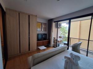 a living room with a couch and a balcony at Rawai Sea Escape 1BR With Rooftop Pool in Rawai Beach