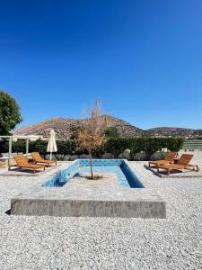 a small tree in the middle of a courtyard with benches at Βlue Lagoon G6 in Galissas