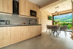 a kitchen and dining room with a table and chairs at Apartamenty Premium VIEW JACUZZI & SAUNA in Kościelisko